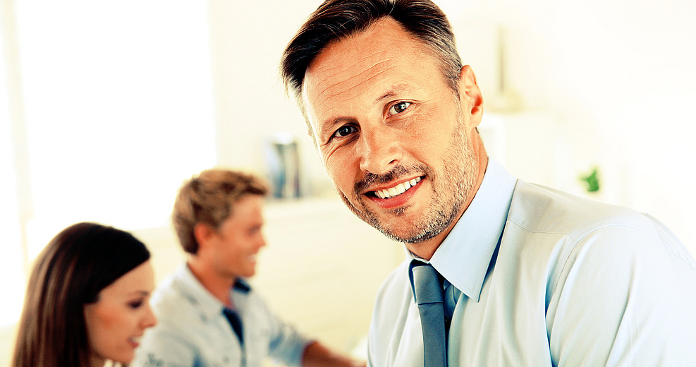 Business manager with employees in background